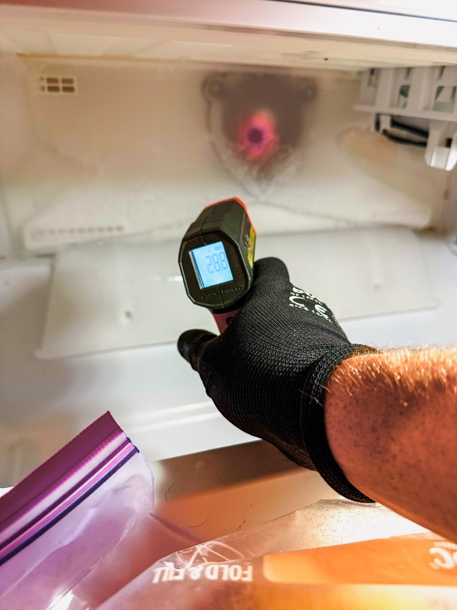 Appliance Rescue Team technician checking a refrigerator's temperature with an infrared thermometer — Appliance Rescue Team serves River Vale, NJ