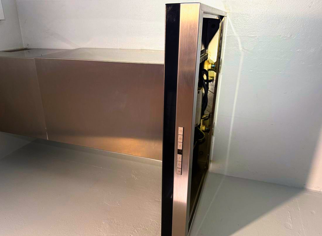 Appliance Rescue Team technician servicing a stainless under-cabinet range hood with the blower housing opened in Bergen County, NJ